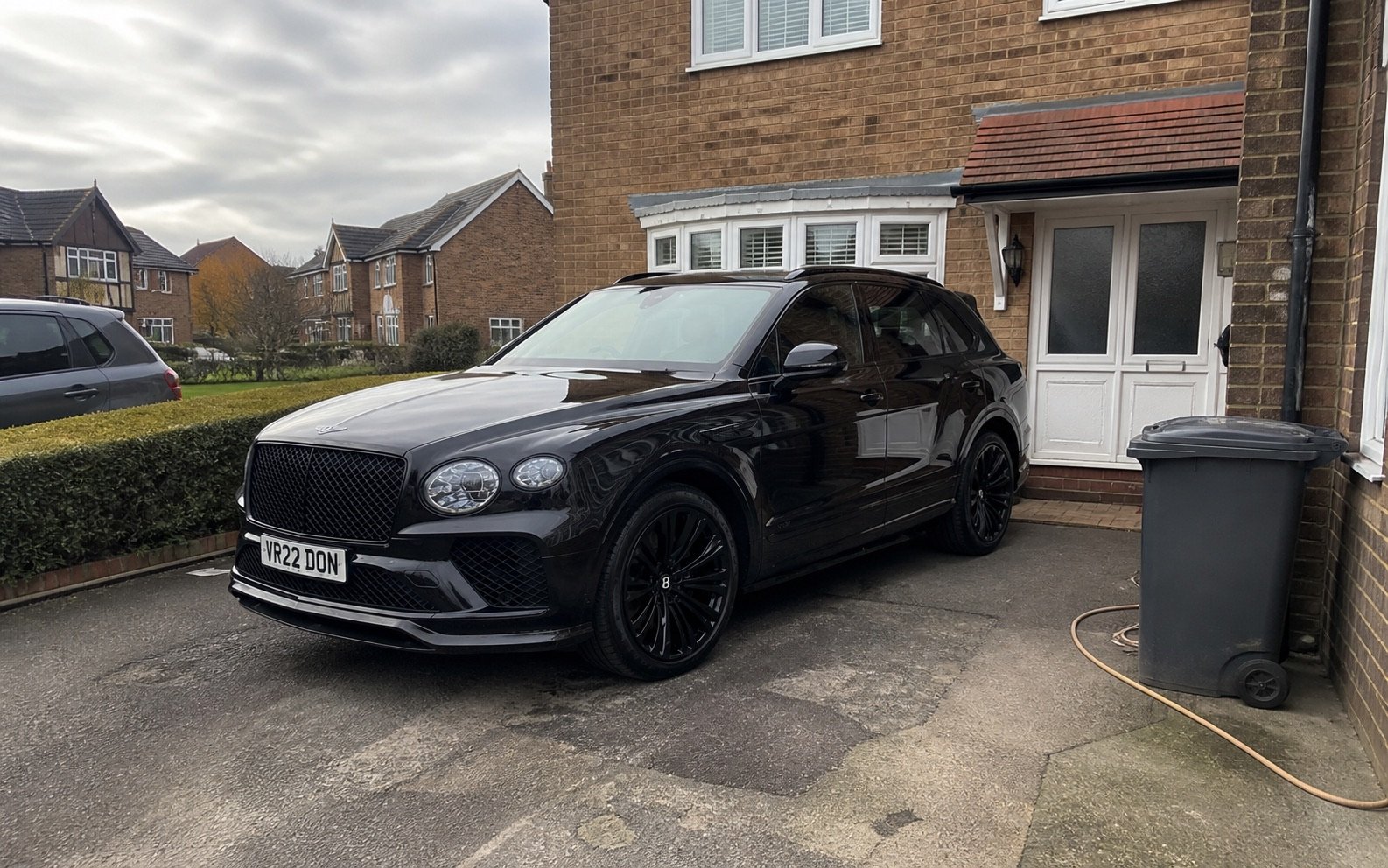 A black 2022 Bentley Bentayga photographed casually on a domestic UK driveway